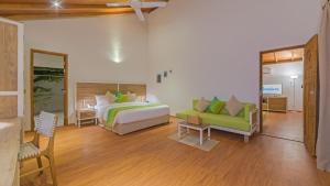 - une chambre avec un lit et un canapé dans l'établissement Innahura Maldives Resort, à Lhaviyani Atoll