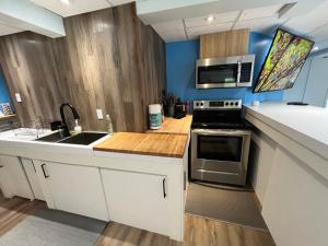 a kitchen with a sink and a microwave at Sweet Home des Suites North Hatley in North Hatley