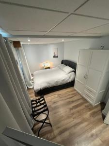 1 dormitorio con 1 cama y 1 silla en Sweet Home des Suites North Hatley, en North Hatley