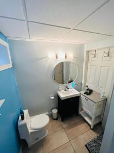 a bathroom with a toilet and a sink and a mirror at Sweet Home des Suites North Hatley in North Hatley