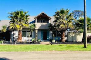 uma casa com palmeiras em frente em Baja Beach Lodge em Indented Head