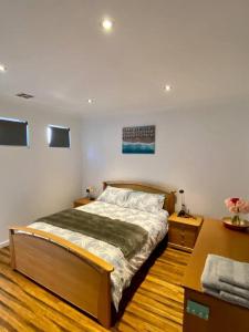 um quarto com uma cama e piso em madeira em Baja Beach Lodge em Indented Head