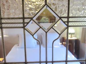 a bedroom with a white bed with a mirror at Beaconstone - off grid retreat in Charleston