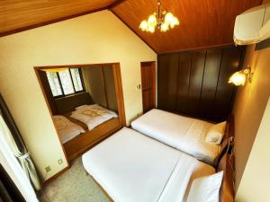 a small room with two beds and a mirror at Cottage Hotel Fenice Hakuba 2-Bedroom house - 1km to Hakuba Goryu in Hakuba +7 photos