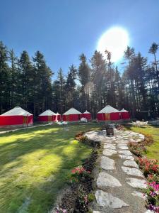 a group of red and white tents in a field at The Glamping Spot Kalam in Kalām