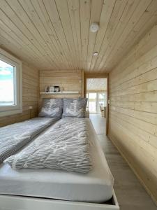 uma cama num quarto com tecto em madeira em Hausboot Janne Lübeck Inclusive Kanu nach Verfügbarkeit SUP und WLAN 50 MBit s Flat em Lübeck