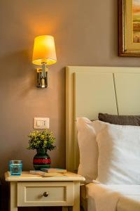 1 dormitorio con 1 cama y 1 mesa con lámpara en Marlin Rooms, en Cagliari