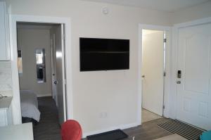 sala de estar con TV de pantalla plana en la pared en Ground Level One Bedroom Suite, en Surrey