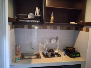 a kitchen counter with a sink and a drying rack at NEW KUBU DI BUKIT apartemen & motor bike rental in Jimbaran