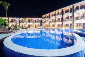 a swimming pool in front of a building at night at Vang Vieng Diamond Resort in Vang Vieng