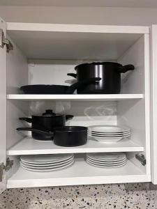a kitchen shelf with pots and pans and plates at Sten apartment Zagreb in Zagreb +17 photos