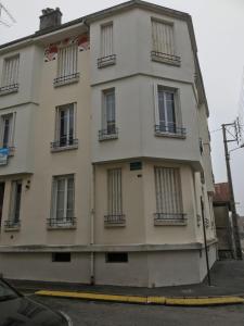 a large white building with windows on a street at Maison du Bonheur l Art de vivre à la française Logement entier avec parking in Sainte-Savine