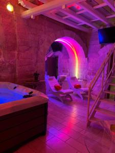 um quarto com jacuzzi e iluminação roxa em B&B Sul Ponte em Gravina in Puglia