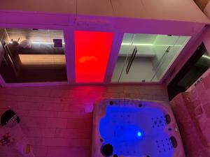 グラヴィーナ・イン・プーリアにあるB&B Sul Ponteのバスルーム(紫と赤の照明付きのバスタブ付)