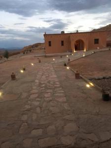 een gebouw midden in een woestijn met lichten bij Berberbayt lodge maison privé in Tinerhir