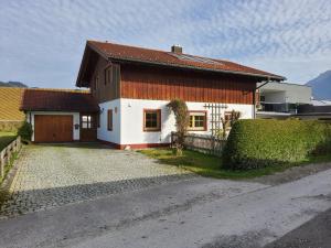 een huis met een hek en een oprit bij Ferienhaus Inntal in Oberaudorf