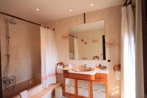W łazience znajduje się umywalka, wanna i lustro. w obiekcie Petit Hotel Ses Rotges - Only Adults w Cala Ratjada +37 zdjęć