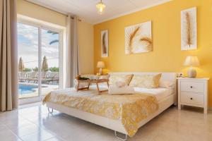 a bedroom with a bed and a table and a pool at Villa Gota de Mar in Jávea