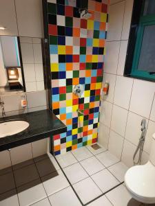 a bathroom with a colorful shower and a sink at Hotel Casa De Patio in Porvorim