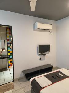 a white room with a bed and a tv at Hotel Casa De Patio in Porvorim