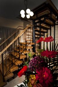 a vase of flowers on a table with stairs at Pension Casa Gia in Cluj-Napoca