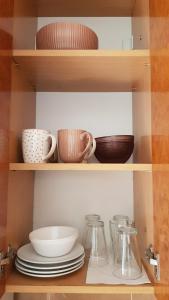 a shelf with plates and bowls and other dishes at Experience Novi Sad Residence in Novi Sad +137 photos