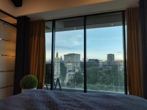 a bedroom with a large window with a view of a city at Sky City Panoramic in Iaşi