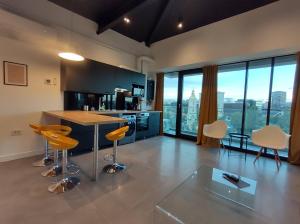 a kitchen with a counter and chairs in a room at Sky City Panoramic in Iaşi