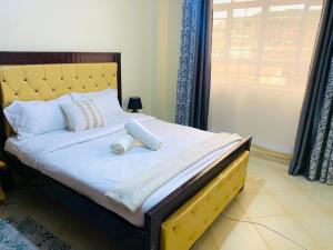 ein Bett mit zwei Kissen darauf in einem Schlafzimmer in der Unterkunft Vee's Homestay, Nakuru Town in Nakuru