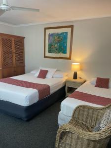 een hotelkamer met 2 bedden en een tafel met een lamp bij Kyamba Court Motel in Mooloolaba