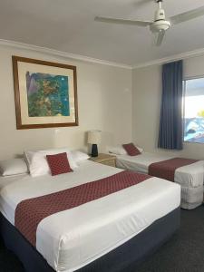 a hotel room with two beds and a window at Kyamba Court Motel in Mooloolaba