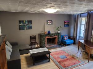 een woonkamer met een bank en een open haard bij Bel Appartement Bagneres De Luchon Centre in Luchon