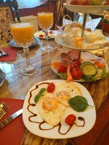 a table with plates of food and glasses of orange juice at Villa Imperia, Museums-Hotel, Treppensteigen in Blankenburg
