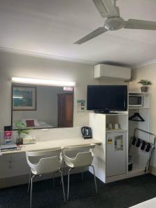 an office with a desk with two chairs and a tv at Kyamba Court Motel in Mooloolaba