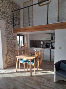 uma cozinha e sala de jantar com uma mesa de madeira e cadeiras em Gîte Mascotte em La Gresle