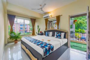 a bedroom with a large bed and a balcony at 2BHK Stunning Apartment with Pool in Vagator +23 photos