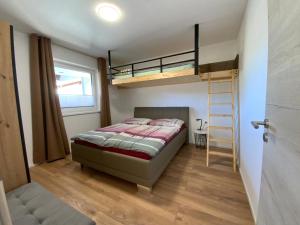 ein Schlafzimmer mit einem Etagenbett und einer Leiter in der Unterkunft Deluxefort für 10 Gäste mit eigenem Whirlpool und Fasssauna in Imst