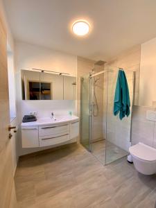 ein Bad mit einer Dusche, einem Waschbecken und einem WC in der Unterkunft Deluxefort für 10 Gäste mit eigenem Whirlpool und Fasssauna in Imst