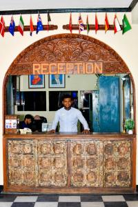Un homme debout derrière un comptoir dans un restaurant dans l'établissement Minara Miwili - Forodhani Park, à Zanzibar City