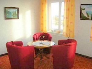 a room with red chairs and a table and a window at Ruegen_Fewo 285 in Neu Mukran