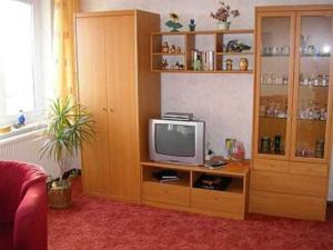 a living room with a tv on a wooden entertainment center at Ruegen_Fewo 285 in Neu Mukran