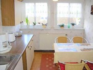 eine Küche mit einem Waschbecken und einem Tisch mit Stühlen in der Unterkunft Rügen-Fewo 285 in Neu Mukran