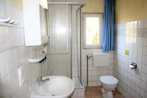 a bathroom with a sink and a toilet and a window at Ruegen_Fewo 285 in Neu Mukran