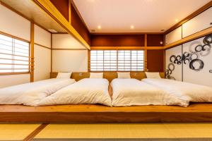Una cama o camas en una habitación de Yuimaru EAST - 最大18名貸切OK