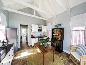a living room with a table and a kitchen at Kalliste an exclusive retreat in Bettyʼs Bay