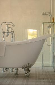 a white bath tub with a faucet in a bathroom at Farlam Hall Hotel & Restaurant in Brampton