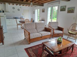 a living room with two couches and a table at gîte de bon air in Sens-de-Bretagne
