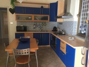 a kitchen with blue cabinets and a table and chairs at Fuoco dell’Etna in Nicolosi