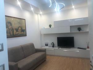 sala de estar con sofá y TV de pantalla plana en RaffaelloElegante appartamento ideale casa vacanze affari, en Milán