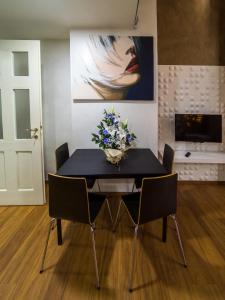 a black dining room table with chairs and a vase of flowers at IDEAL LOFT IN CENTRO TORINO in Turin